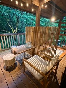 a porch with a bench and a table on a deck at 森権太 Forest Gonta in Takamori