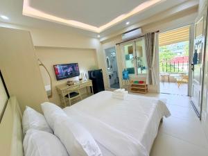 a bedroom with a large white bed and a television at Huko House in Ho Chi Minh City