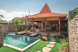 a house with a swimming pool in a yard at Villa Danginan & Dajanan Pemuteran in Pemuteran