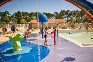 a young boy playing at a water park at Mobil home 3ch, clim, bord de mer in Seignosse