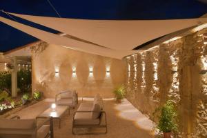 a patio with chairs and a stone wall at Hôtel Les Comtes de Pardiac in Marciac