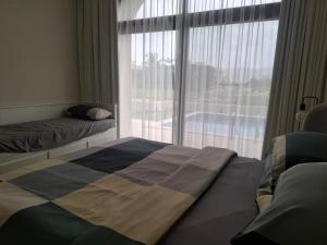 a bedroom with two beds and a large window at Tulip River View in Ma‘mūrah +7 photos