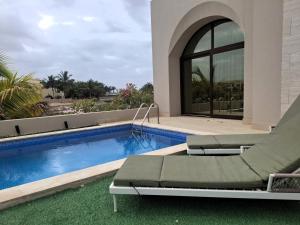 a swimming pool with a chair next to a house at Tulip River View in Ma‘mūrah