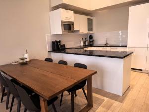 a kitchen with a wooden table and a counter top at Tulip River View in Ma‘mūrah