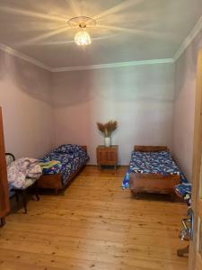 a room with two beds and a ceiling at Madisha's Guesthouse in Mestia