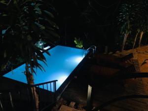 a swimming pool lit up at night at The Nook in Deraniyagala