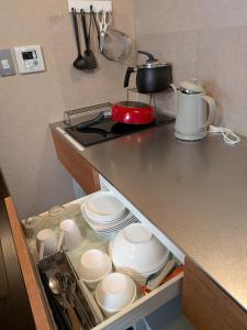 a kitchen counter with plates and a pot on a stove at Dragon Inn Nikko in Nikko