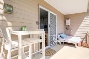 a patio with a table and chairs on a porch at Kingscliff Spacious Beach Cottage in Kingscliff