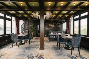 a dining room with tables and chairs and windows at Bay Luxury Fortune Grand Hotel in Hanoi