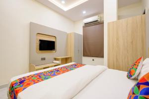 a bedroom with a large bed and a tv at FabHotel RR Inn in Kānpur
