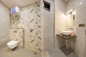 a bathroom with a toilet and a sink at FabHotel RR Inn in Kānpur +20 photos