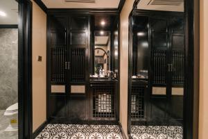 a bathroom with a shower with black doors and a toilet at Bay Luxury Fortune Grand Hotel in Hanoi +74 photos