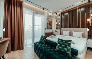 a bedroom with a large bed and a green couch at BW LUX STUDIO-Belgrade Waterfront in Belgrade