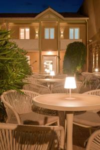 a patio with tables and chairs and a building at Hôtel Les Comtes de Pardiac in Marciac +22 photos