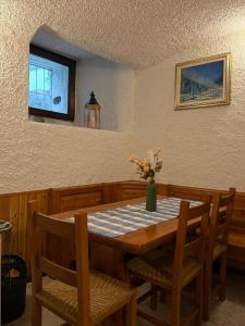 a dining room table with a vase of flowers on it at Mountain Getaway Panoramic View - Pets Welcome in Gromo