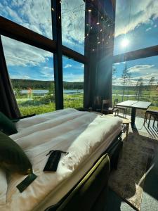 a large bed in a room with a large window at Jänkä Resort in Äkäslompolo