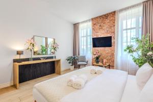 a bedroom with a white bed and a brick wall at Hotel Jazz Market Square Wroclaw in Wrocław