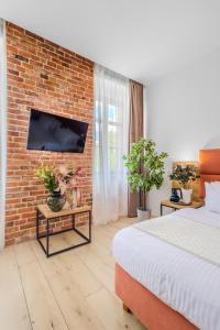 a bedroom with a bed and a brick wall at Hotel Jazz Market Square Wroclaw in Wrocław +46 photos