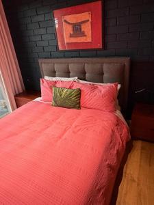 a bedroom with a bed with a pink comforter at Oasis at Aldinga Beach in Aldinga Beach