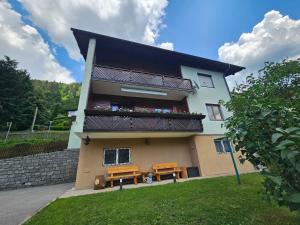 a building with two benches and a balcony at Mirnockblick Apartments 2 in Radenthein