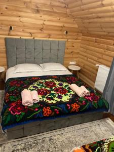 a bedroom with a bed with a floral comforter at Casa Moroseneasca Breb in Breb
