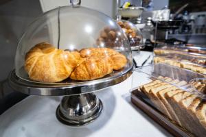 a display case with croissants and other pastries in a bakery at Argus Hotel Darwin in Darwin