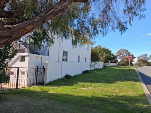 a stop sign in front of a white house at Como Beach Apartment 2 in Perth