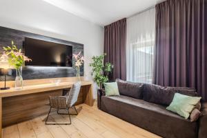 a living room with a couch and a desk at Hotel Jazz Market Square Wroclaw in Wrocław