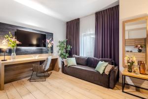a living room with a couch and a desk at Hotel Jazz Market Square Wroclaw in Wrocław