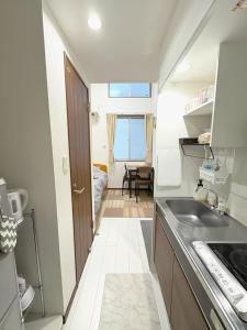 a small kitchen with a sink and a room at The Scene Fuchinobe in Sagamihara