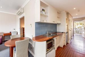 a kitchen with a sink and a table in a room at Caves House Apartments Yallingup in Yallingup