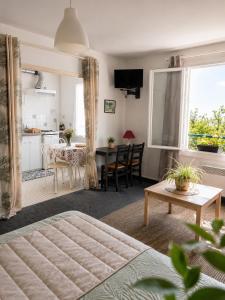 a living room with a bed and a kitchen at Hôtel La Coursive Oléron in Saint-Pierre-dʼOléron