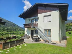 a house with a balcony and a patio with a table at Mirnockblick Apartments in Radenthein