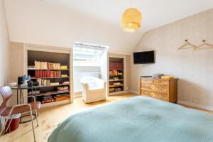 a bedroom with a bed and a desk and a tv at Une Chambre À Lestriguiou in Plomeur