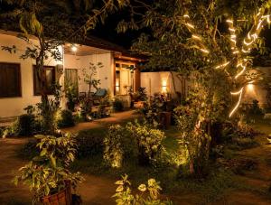 a house with lights in the yard at night at Trio Mango Stay in Arugam Bay +12 photos