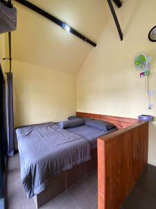 a bedroom with a bed in the corner of a room at Cozzy Boemi Chips Pangalengan in Palayangan