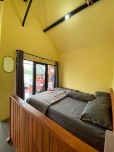 a large bed in a room with a large window at Cozzy Boemi Chips Pangalengan in Palayangan