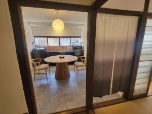 a room with a table and chairs and a kitchen at Rinku Base Ichi in Tajiri +20 photos