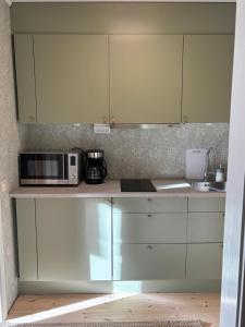 a kitchen with white cabinets and a microwave at Hannas hus in Karlskrona +4 photos