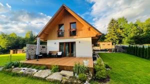 a house with a wooden deck in a yard at Evelin, Slovakia in Habovka