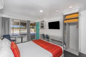 a hotel room with a bed and a desk at Econo Lodge Alabaster Motel Cowra in Cowra +86 photos