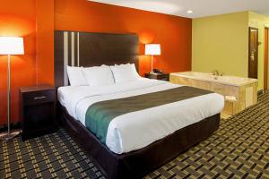 a hotel room with a large bed and a bathroom at Quality Inn Plainfield I-395 in Plainfield