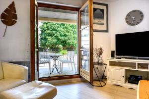 a living room with a sliding glass door leading to a patio at Chez Romane in Riquewihr