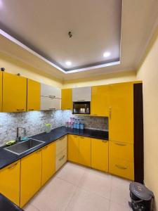 a kitchen with yellow cabinets and a sink at Unique Nest Homestay in Guwahati +6 photos