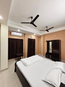 a bedroom with a large bed with a ceiling fan at Unique Nest Homestay in Guwahati