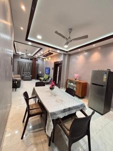 a dining room with a table and chairs and a living room at Unique Nest Homestay in Guwahati