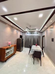 a dining room with a table and a refrigerator at Unique Nest Homestay in Guwahati