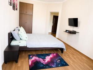 a bedroom with a bed and a tv on a wall at Apartment Ekaterina in Chornomorsk
