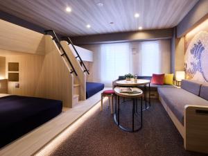 a room with a bed and a couch and a table at Minn Namba Nipponbashi in Osaka