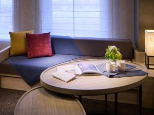 a living room with a couch and a table with books at Minn Namba Nipponbashi in Osaka